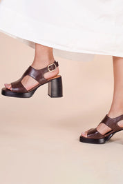 A model wearing the Iraia Leather Heel in colour Chestnut, from the front, showing the whole outfit