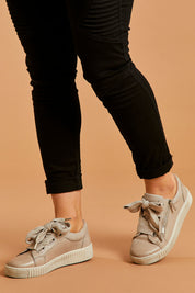 A model wearing size 38 of the Jovi Leather Sneaker in colour Stone (Grey), from the front, cropped image