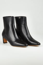 A model wearing size 37 of the Kitan Leather Ankle Boot in colour Black (Black), from the front, showing the whole outfit
