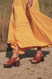 A model wearing the Spicer Leather Heel in colour Brandy, from the front, showing the whole outfit
