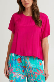 Model Madeline wearing size 10 of the Lux Essentials Top in colour Fushia (Pink), from the front, cropped image