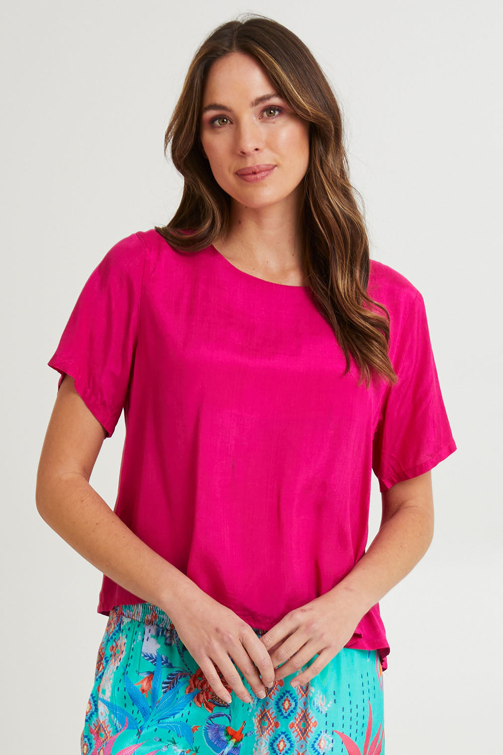 Model Madeline wearing size 10 of the Lux Essentials Top in colour Fushia (Pink), from the front, cropped image