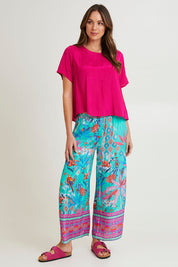 Model Madeline wearing size 10 of the Lux Essentials Top in colour Fushia (Pink), from the front, showing the whole outfit