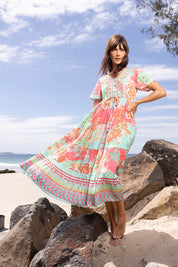 A model wearing the Sarah Midi Dress in colour Print (Green), from the front, showing the whole outfit