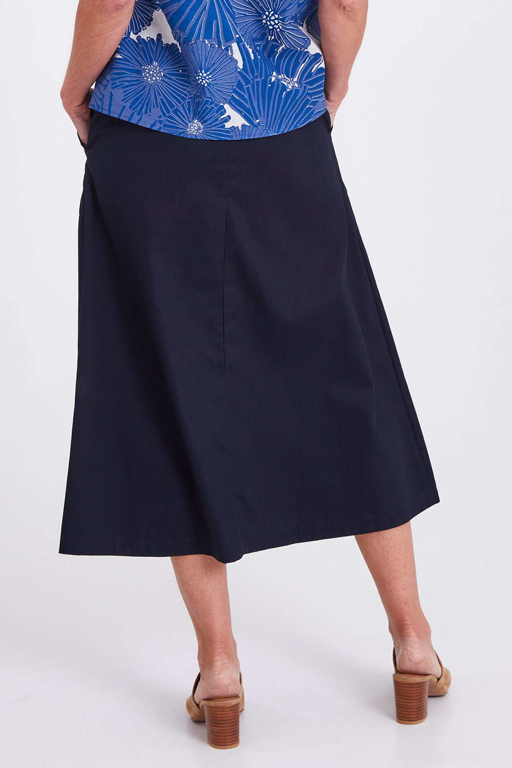 Model Emma wearing size S of the Amy Skirt in colour Navy (Blue), from the back
