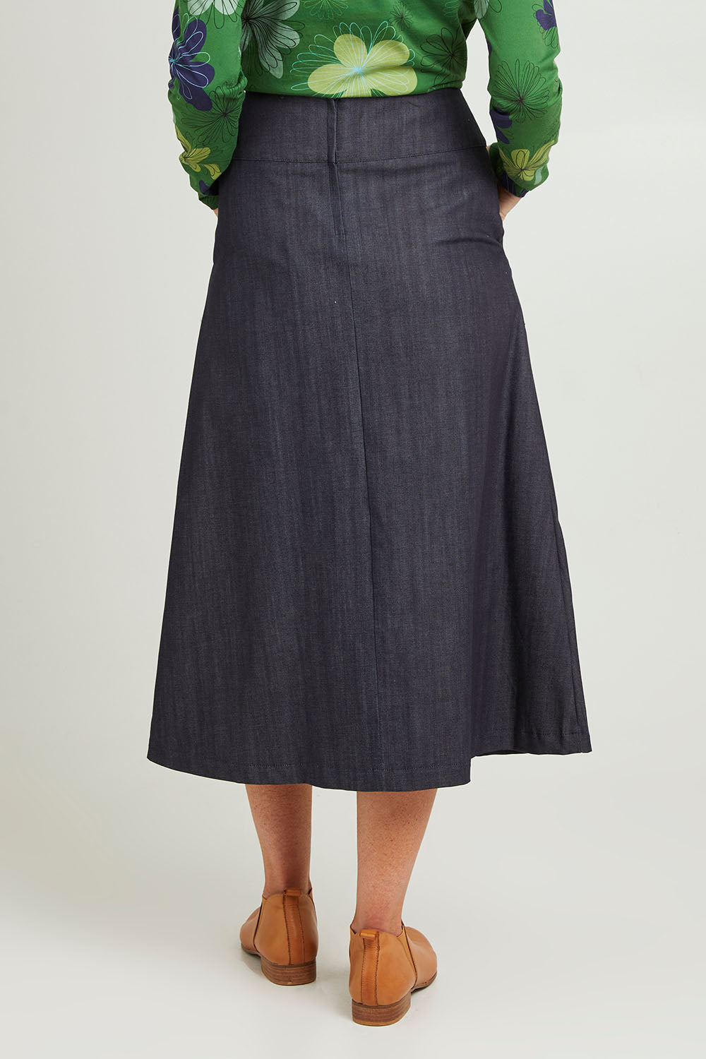 Model Emma wearing size S of the Amy Skirt in colour Denimindig (Blue), from the back