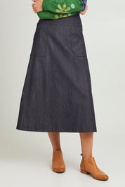 Model Emma wearing size S of the Amy Skirt in colour Denimindig (Blue), from the front, cropped image