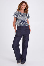 Model Emma wearing size S of the Gabby Denim Pants in colour Indigo (Blue), from the front, showing the whole outfit