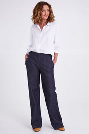 Model Emma wearing size S of the Gabby Denim Pants in colour Indigo (Blue), from the front, showing the whole outfit