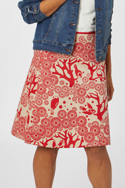 Model Cara wearing size S of the Mikko Aline Skirt in colour LipChino (Red), from the front, cropped image