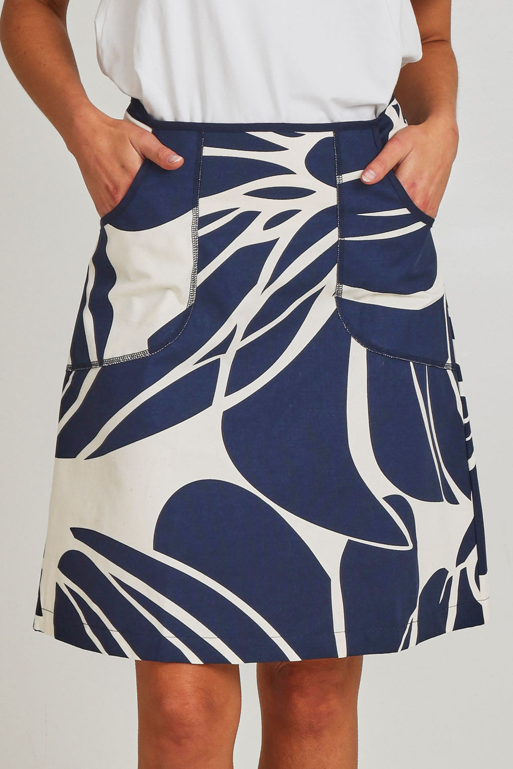 Model Madeline wearing size S of the Avril Cotton Skirt in colour Indigo (Blue), from the front, cropped image
