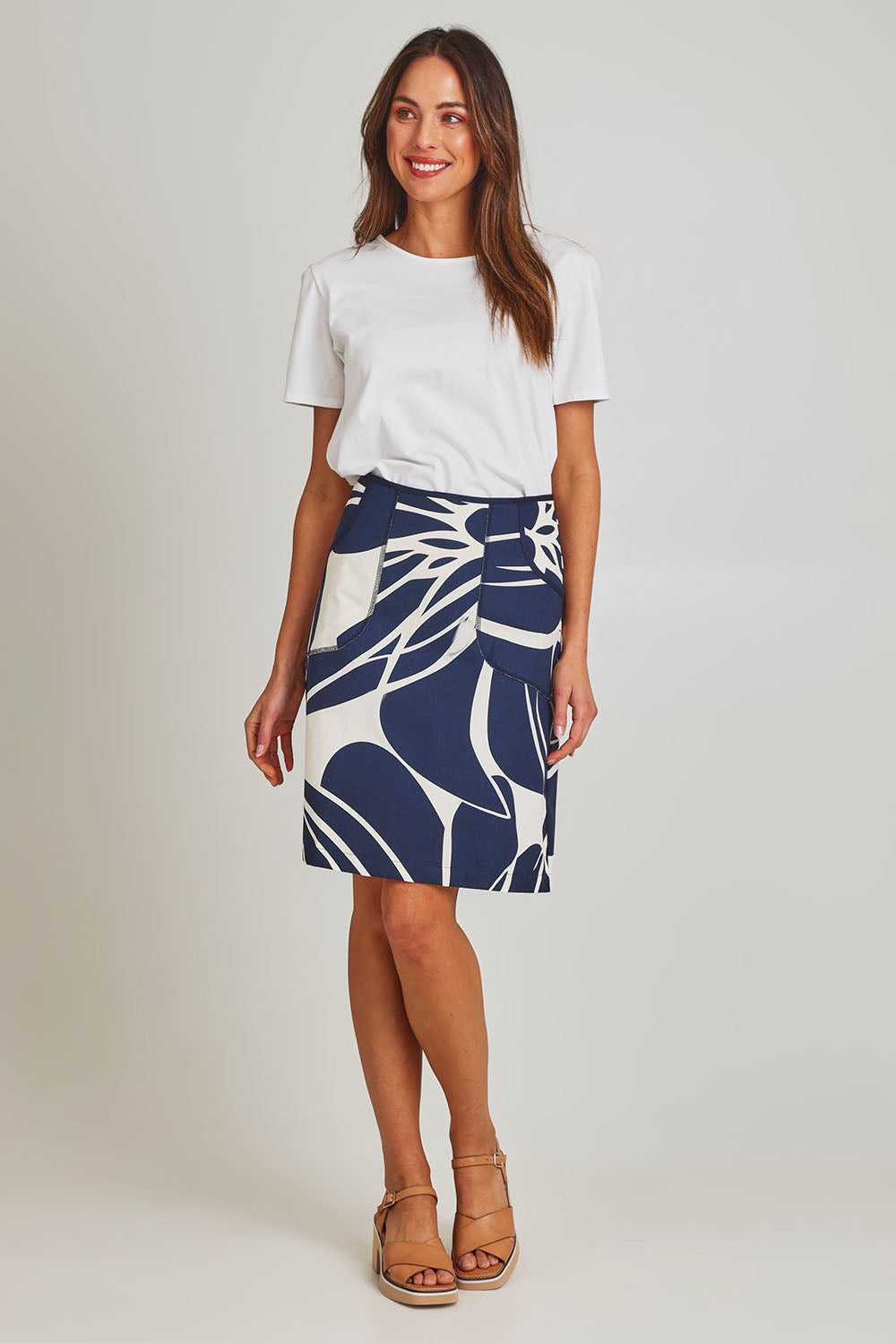 Model Madeline wearing size S of the Avril Cotton Skirt in colour Indigo (Blue), from the front, showing the whole outfit