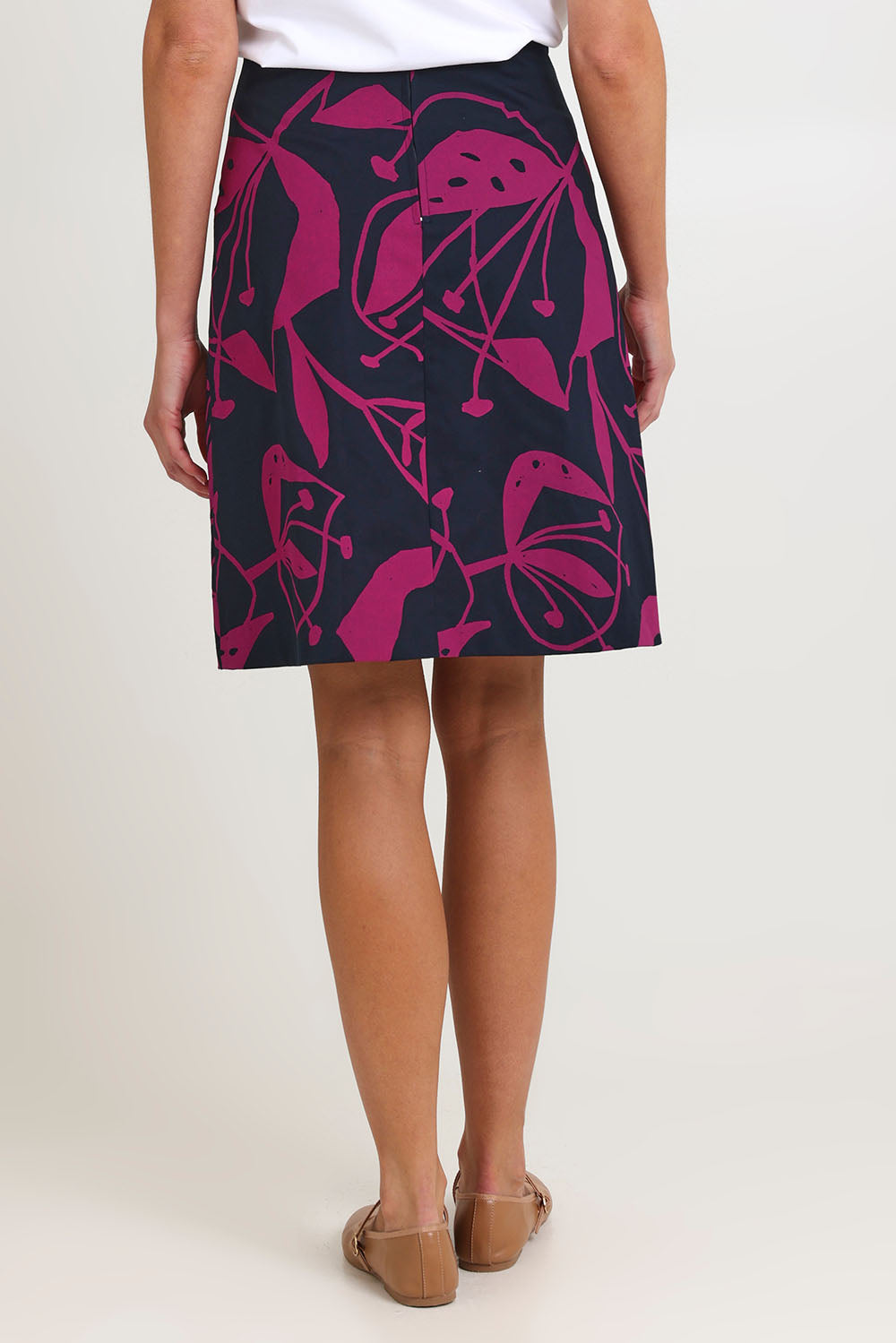Model Madeline wearing size S of the Avril Cotton Skirt in colour Navy (Blue), from the back