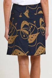 Model Madeline wearing size S of the Ivy Cotton Skirt in colour Navy (Blue), from the back