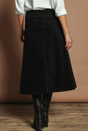 Model Madeline wearing size S of the Amy Cord Midi Skirt in colour Black (Black), from the back