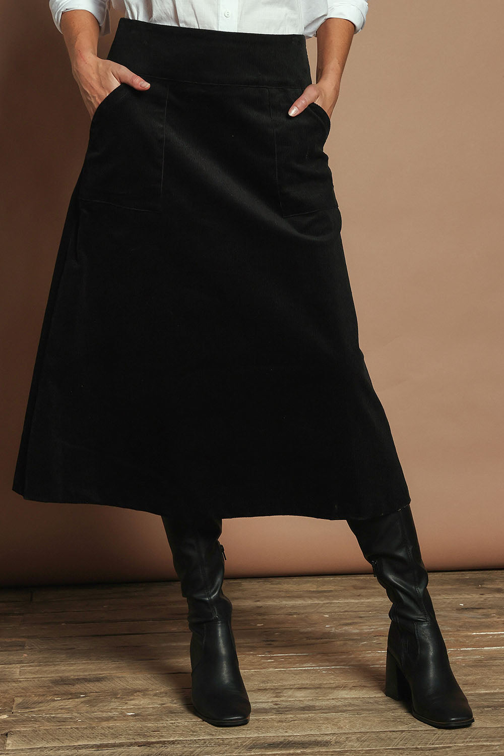 Model Madeline wearing size S of the Amy Cord Midi Skirt in colour Black (Black), from the front, cropped image