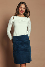 Model Madeline wearing size S of the Amy Cord Skirt in colour Teal (Blue), from the front, cropped image