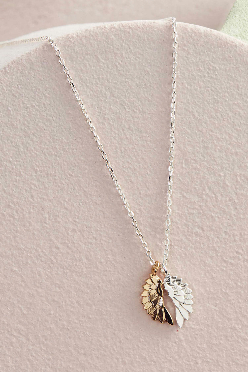 A model wearing the Wings Necklace in colour Silvergold (Metallics), from the front, showing the whole outfit