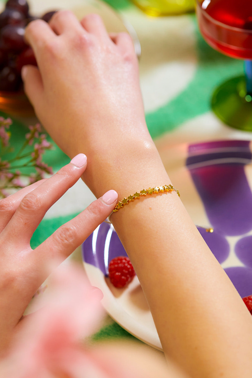 A model wearing the Stars So Bright Bracelet in colour Silvergold (Metallics), from the front, cropped image