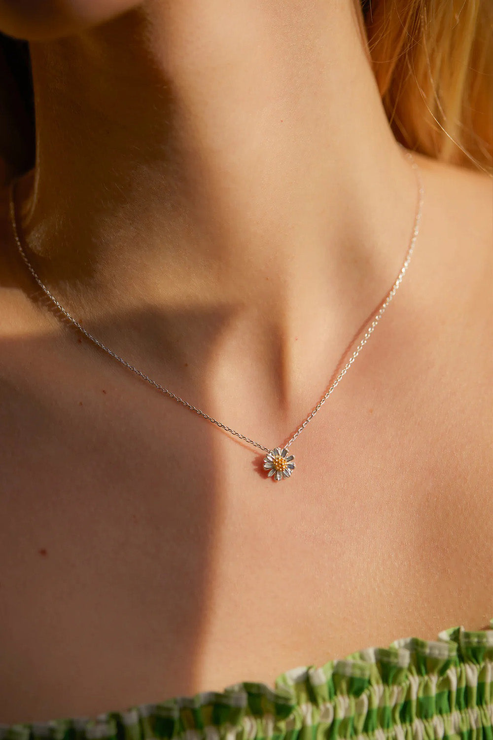 A model wearing the Wildflower Necklace in colour Silver (Metallics), from the front, cropped image