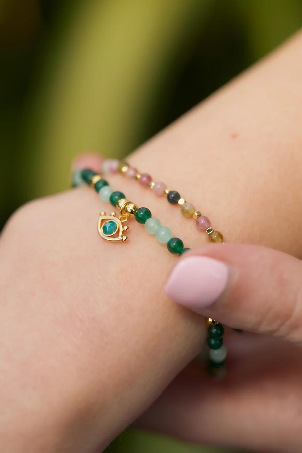 A model wearing the Beaded Evil Eye Bracelet in colour Green (Green), from the front, showing the whole outfit