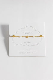 A model wearing the Flower Pearl Hammered Disc Bracelet in colour Goldpearl (Metallics), from the front, showing the whole outfit