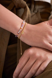 A model wearing the Green & Pink Mixed Mini Bead Bracelet in colour Greenpink, from the front, cropped image