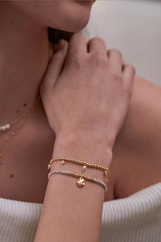 A model wearing the Hammered Charm Beaded Bracelet in colour Silvergold (Metallics), from the front, cropped image