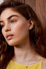 A model wearing the Mixed Moon & Star Stud Earring in colour Gold (Metallics), from the front, cropped image