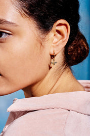 A model wearing the Bee Hoop Earrings in colour Gold (Metallics), from the front, showing the whole outfit