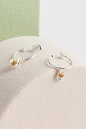 A model wearing the Mini Wildflower Hoop Earring in colour Silver (Metallics), from the front, showing the whole outfit
