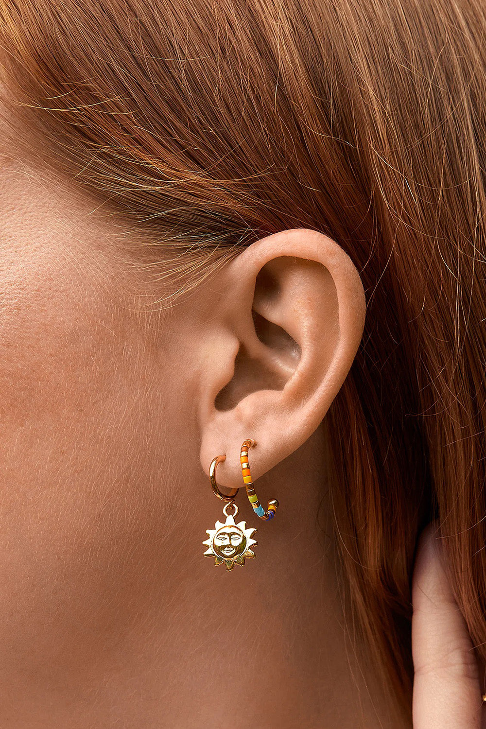 A model wearing the Rainbow Beaded Hoop Earrings in colour Goldrainbo (Metallics), from the front, cropped image