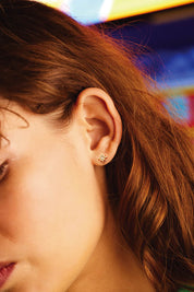A model wearing the North Star Stud Earrings in colour Gold (Metallics), from the front, showing the whole outfit