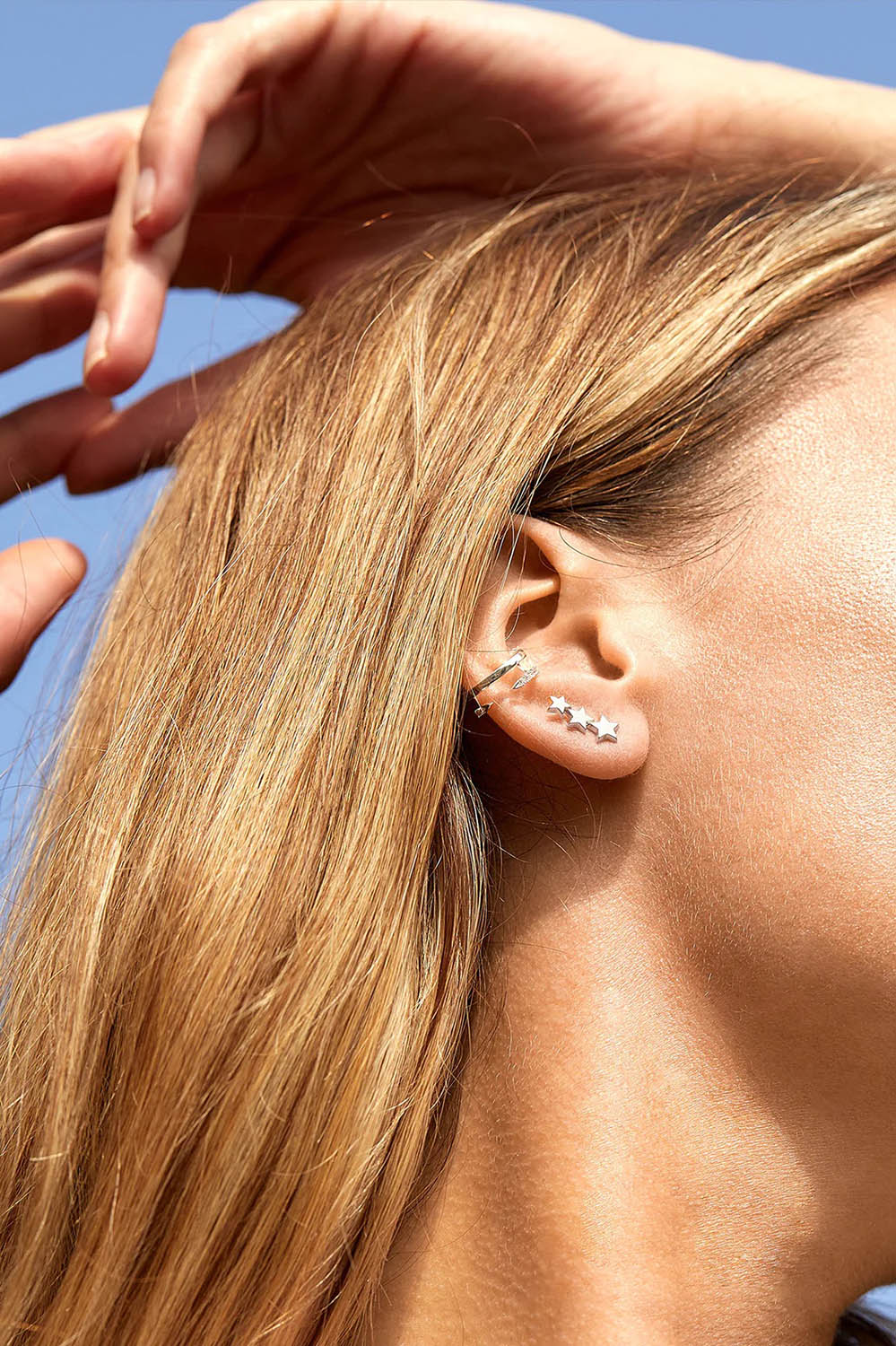 A model wearing the Trio Star Stud Earrings in colour Silver (Metallics), from the front, showing the whole outfit