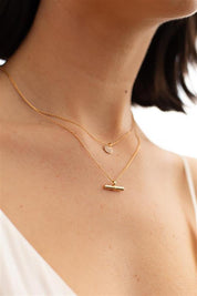 A model wearing the Tin colourBar Necklace - Gold (Metallics), from the front, cropped image