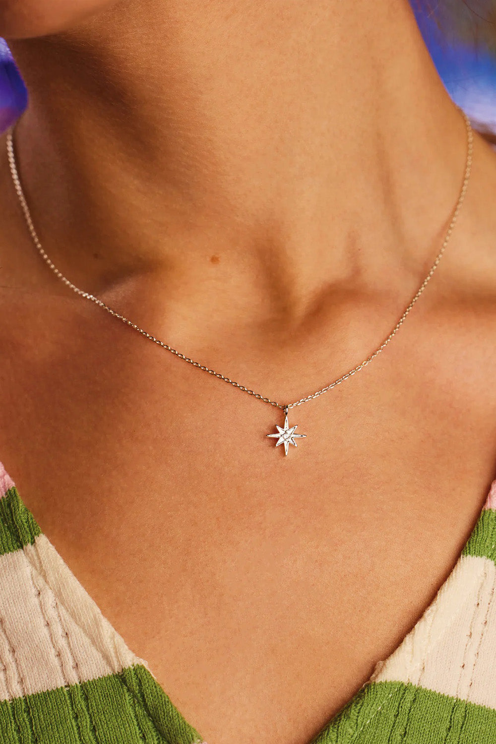 A model wearing the North Star Necklace in colour Silver (Metallics), from the front, cropped image
