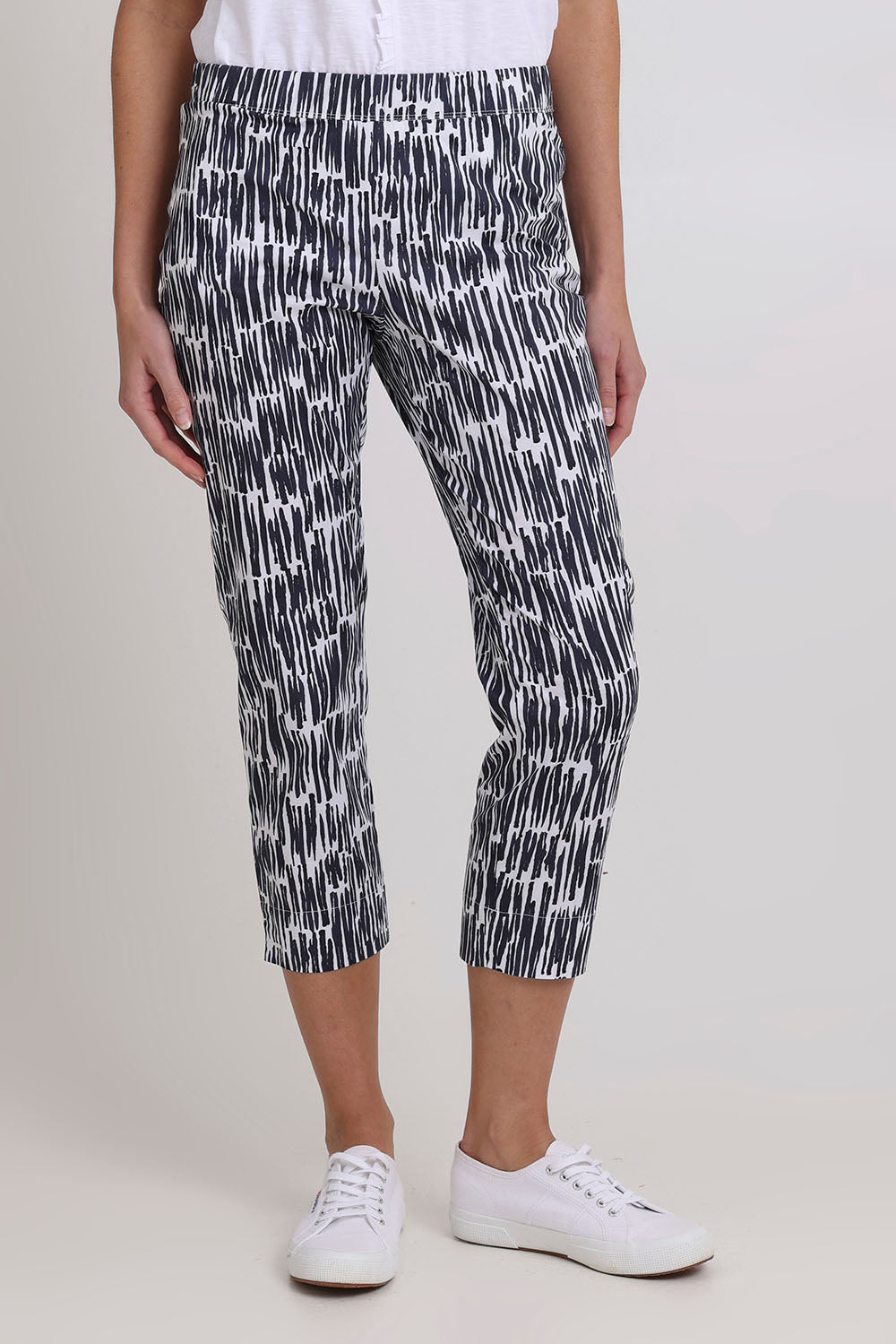 Model Madeline wearing size 10 of the Fuss Free Cotton Blend Taper Capri Trapeze Pant in colour Code (Black), from the front, cropped image