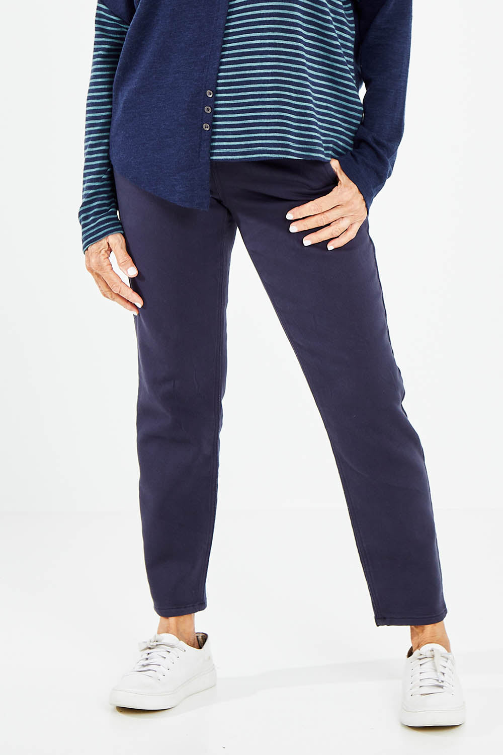Model Elise wearing size 10 of the Final Stretch Jogger in colour Denim (Blue), from the front, cropped image