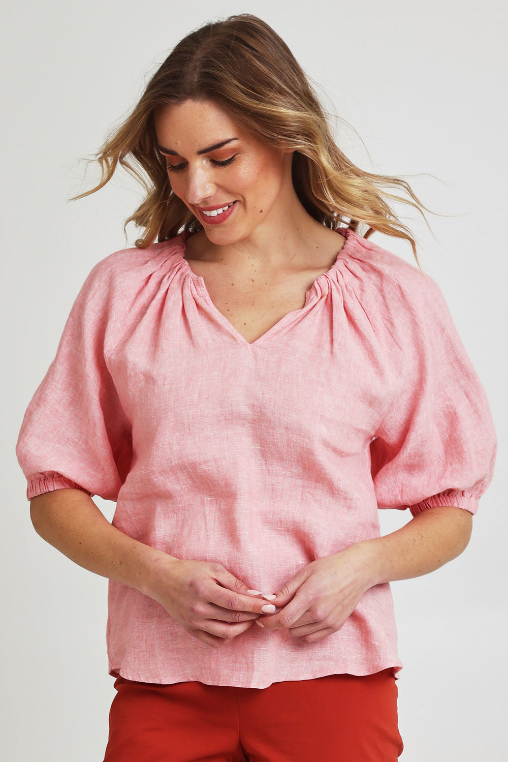 Model Olivia wearing size 10 of the Turn Up The Volume Top in colour Mellowpeac (Pink), from the front, cropped image