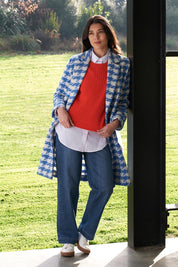 A model wearing the Chain Reaction Merino Vest in colour Squash, from the front, showing the whole outfit