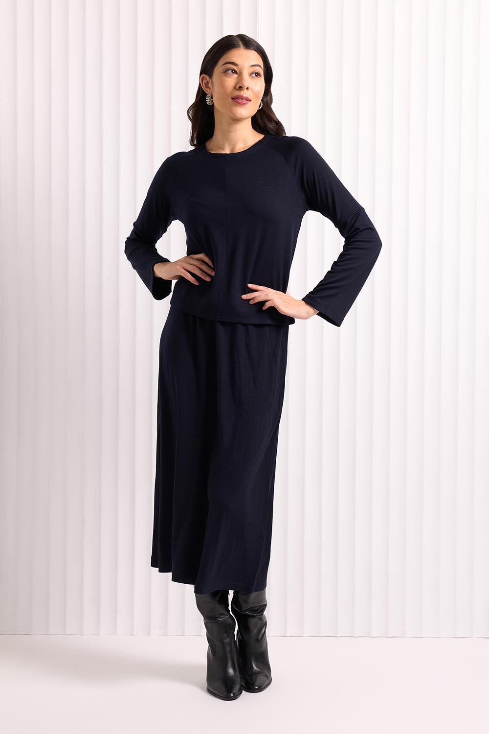 A model wearing the A Game Merino Skirt in colour Futuredusk (Blue), from the front, showing the whole outfit