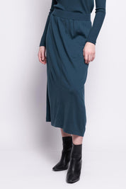 A model wearing the A Game Merino Skirt in colour Jeep (Green), from the front, cropped image