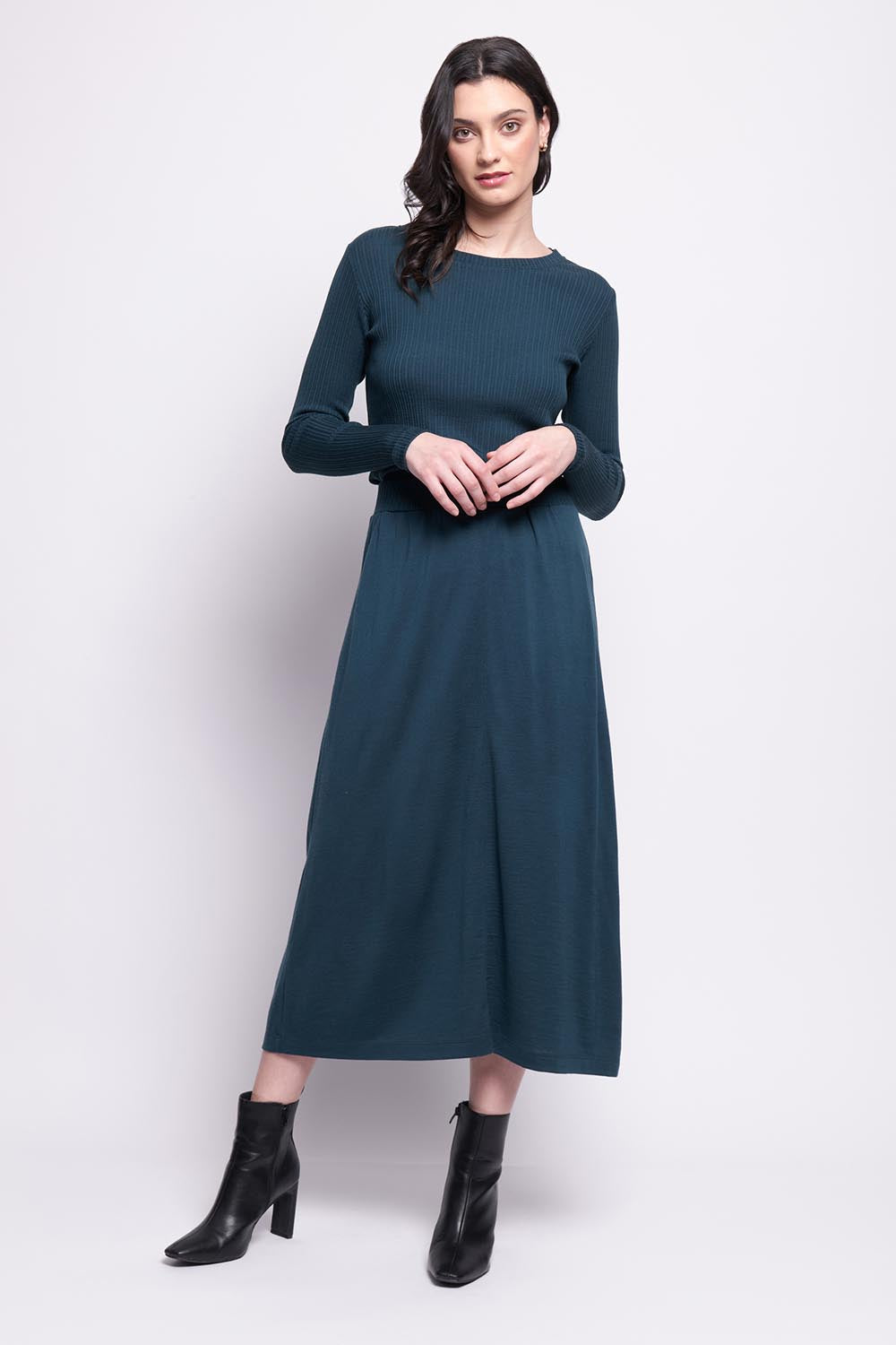 A model wearing the A Game Merino Skirt in colour Jeep (Green), from the front, showing the whole outfit