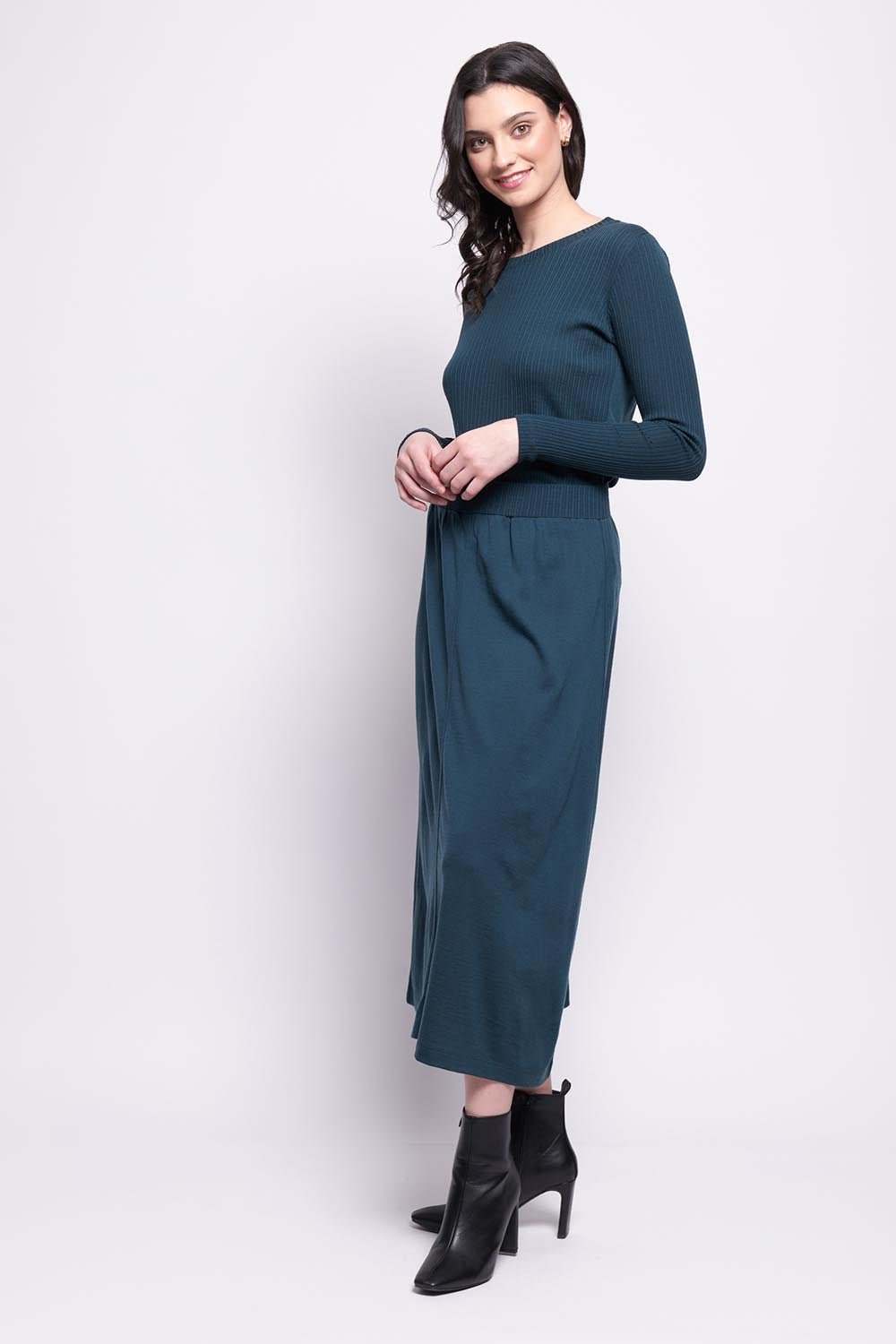 A model wearing the A Game Merino Skirt in colour Jeep (Green), from the front, showing the whole outfit