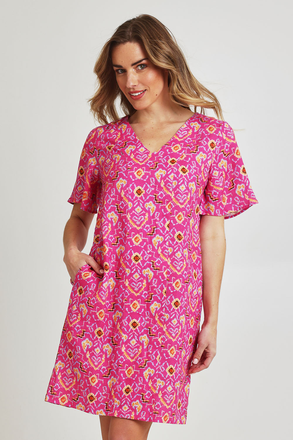 Model Olivia wearing size 10 of the Runway Linen Dress in colour Miami (Pink), from the front, cropped image
