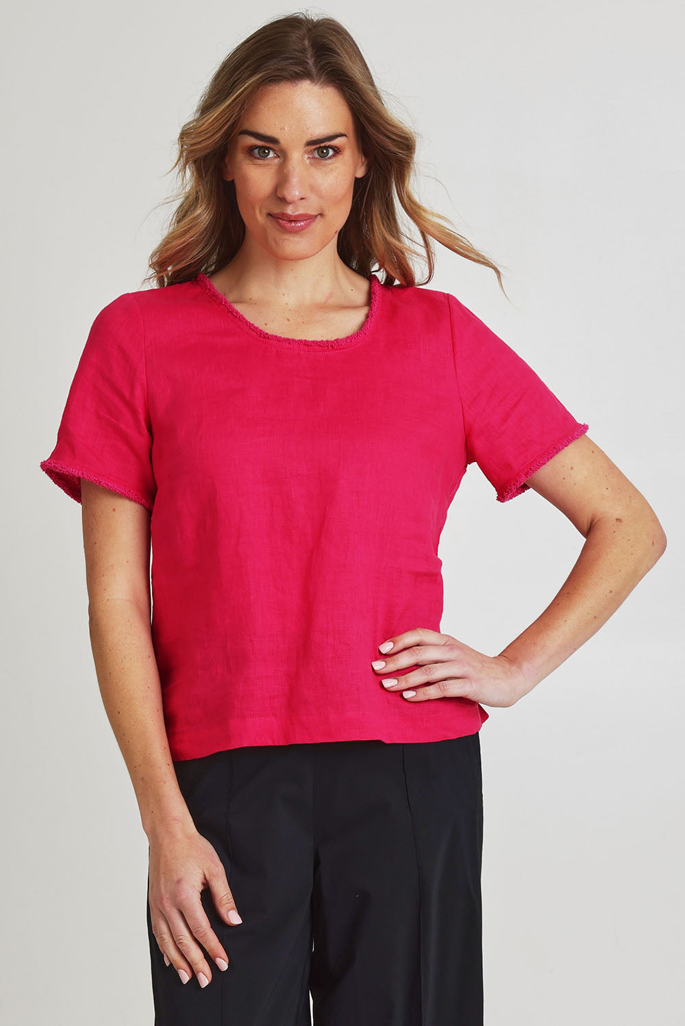 Model Olivia wearing size 10 of the Fringe Benefits Linen Top in colour Pinkflash (Pink), from the front, cropped image