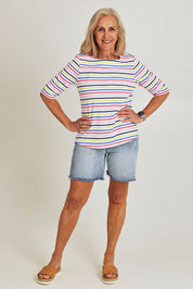 Model Sandy wearing size S of the Even Keel Cotton Top in colour Multistrip (Pink), from the front, showing the whole outfit