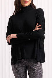A model wearing the Merino Raisin The Baa Sweater in colour Black (Black), from the front, cropped image