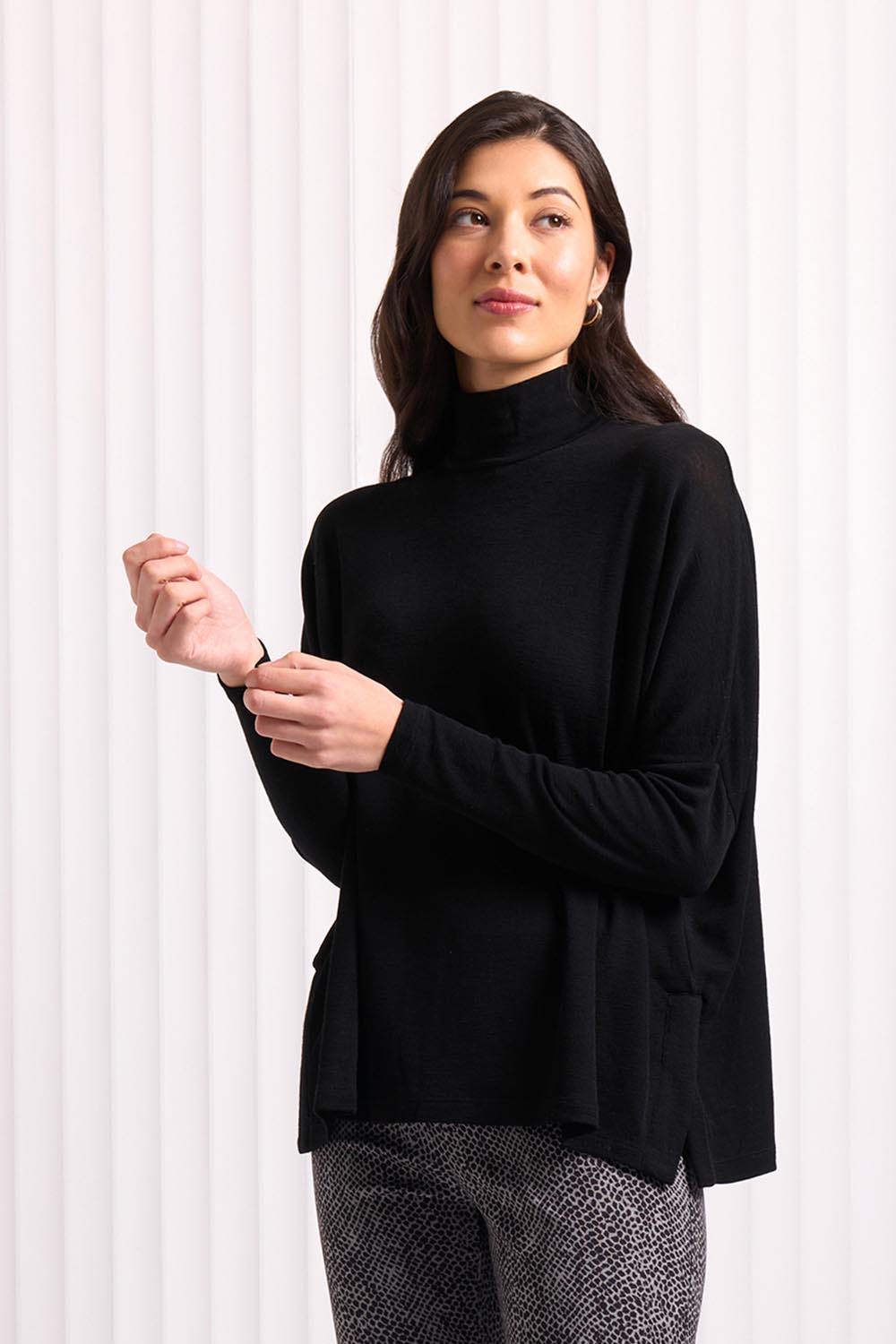 A model wearing the Merino Raisin The Baa Sweater in colour Black (Black), from the front, cropped image