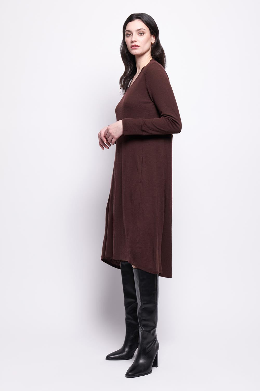 A model wearing the Merino Shear Ecstasy Dress in colour Raisin, from the front, showing the whole outfit